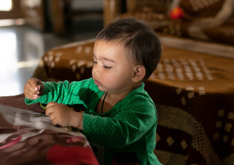 Asian Indian baby girl portrait closeup playing with toys. A cute baby girl .