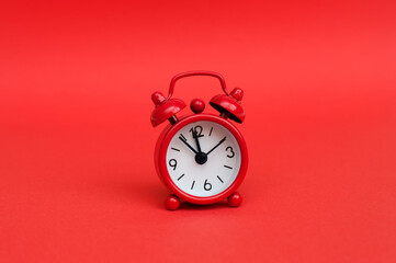 Red alarm clock on red background
