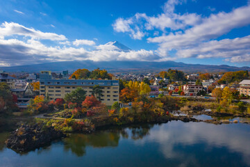 Fujiyama in Japan. Lake Kawaguchiko in autumn. Autumn landscape of Fujikawaguchiko city. Mount Fuji is visible behind the clouds. A bird's eye view of Japan city. Travel to Mount Fujiyama.