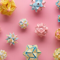 Set of multicolor handmade modular origami balls or Kusudama Isolated on pink background. Visual...