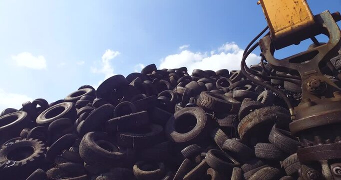 Hill of Used Tires in Recycling Facility on Sunny Day, Low Angle.