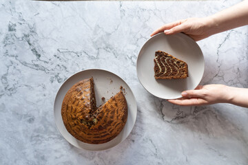 hands holding a plate with cake