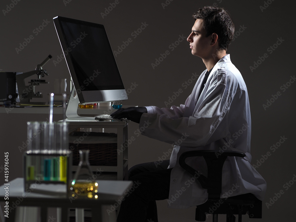 Poster modern scientist work. scientist works using a computer. chemist in a scientific laboratory. he is t