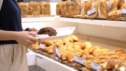 Someone takes a bun in the confectionery department of a bakery or supermarket. 4k