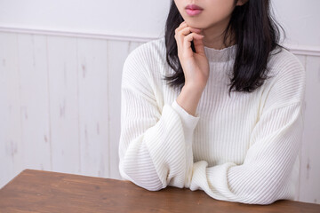 白い服を着た女性が悩んでいる姿　woman worry