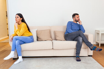 Fototapeta premium Husband and wife sitting on the couch and not talking after an argument at home. Social Distancing concept