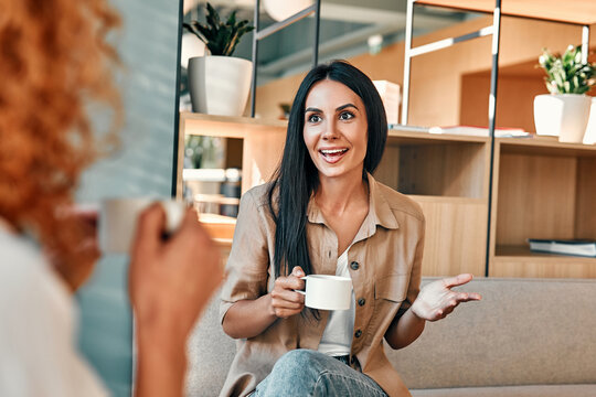 Young business partners drinking coffee in coffeeshop