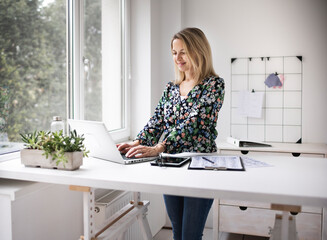 Businesswoman working at ergonomic standing desk.