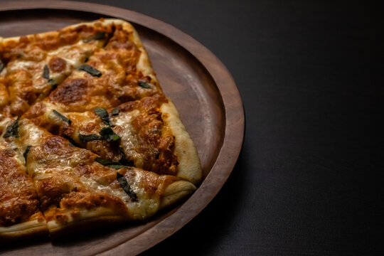 High angle shot of yummy pizza on a black surface with copy space.