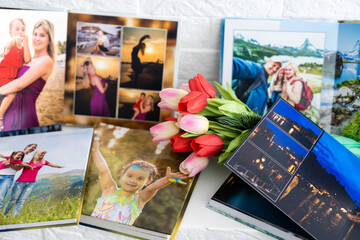 photo book and flowers tulips as a holiday gift lie on the shelf