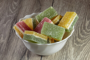 Multi colored layered marmalade in a dish. Closeup of wonderful dessert.