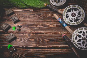 Old rarity bottom fishing reels on a wooden background. Bell, fish tank and makuha cubes.