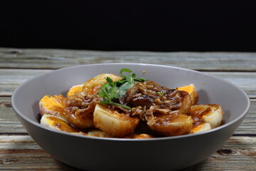 Pile of cutting boiled egg seasoning with sweet tamarind sauce serving on the plate. Famous traditional ancient menu in Asia restaurant. 