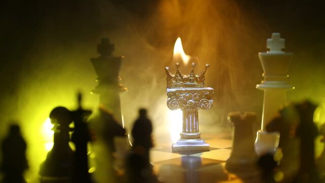 Beautiful crown miniature on chessboard. chess board game concept of business ideas and competition and strategy ideas concept. Chess figures on a dark background with smoke and fog. Selective focus
