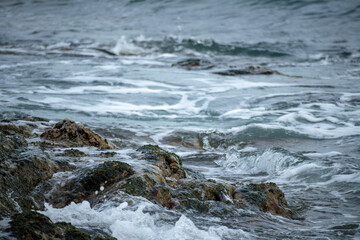 波打ち際の岩に打ちつける波しぶき