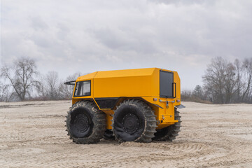 Unique all-terrain vehicle in a sandy area on a cloudy winter day