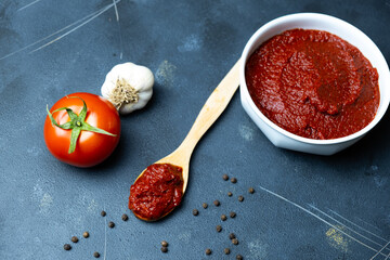 Tomato paste, tomato paste on wooden spoon, top view.