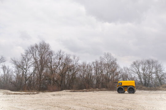 Yellow off-road vehicle driving in the sands on a cloudy winter day