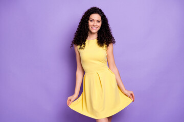 Portrait of satisfied curly hairstyle person arms touch dress look camera isolated on purple color...