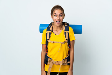 Young mountaineer woman with a big backpack isolated on white background with surprise facial expression