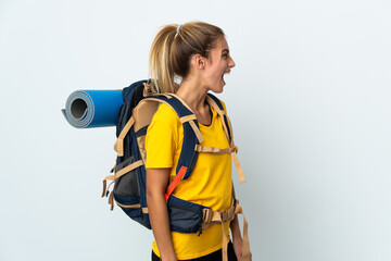 Young mountaineer woman with a big backpack isolated on white background laughing in lateral...