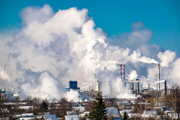 Silhouettes of buildings seen through the smoke smog from manufacturing. Ecological concept.