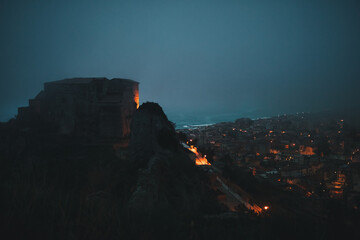 Castle of Carafa at night inside the fog. Roccella Jonica, Calabria Italy