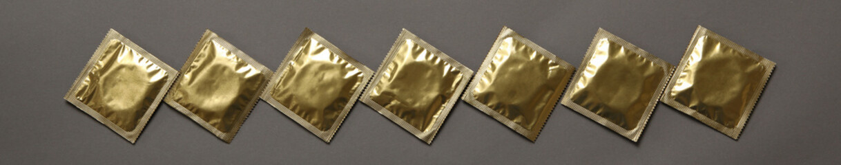 Blank condoms on gray background, top view