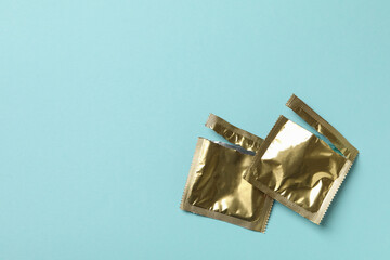 Empty blank condom packagings on blue background