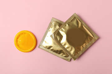 Yellow condom and blank condoms on pink background