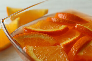 Fototapeta na wymiar Bowl of orange jelly with orange slices, close up