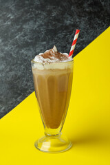 Glass of chocolate milkshake on two tone background
