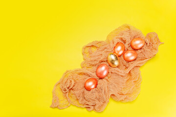 Bright happy easter holiday background with pearl pink and golden eggs in the nest over yellow