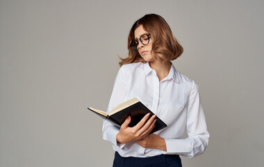 Business woman with a notebook in her hands and glasses on her face