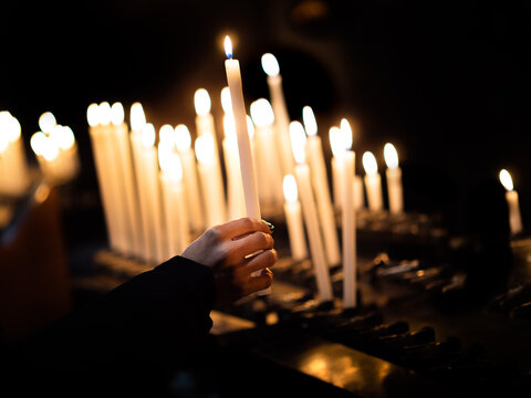 woman hand lighting candles in a church