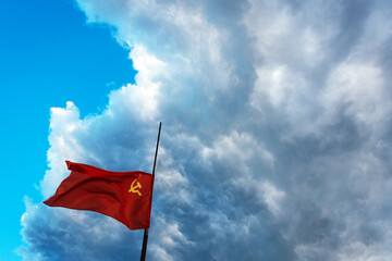 the flag of the soviet union develops against a blue sky