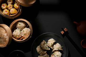 Dimsum on plate and bamboo steamer with dumplings on the table with copy space in restaurant
