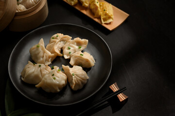 A plate of dumplings on dinning table with chopstick and copy space in Chinese restaurant