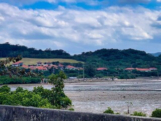 Fototapeta na wymiar 沖縄の田舎の村の晴れた日の静かな田園風景とリゾートホテル