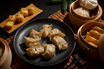 A plate and bamboo steamer of Dimsum dumplings in Chinese restaurant