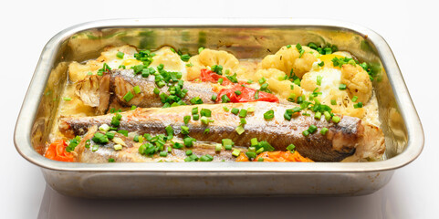 hake fish baked with vegetables close view, baking tray with tomatoes, broccoli and spices, home cooking