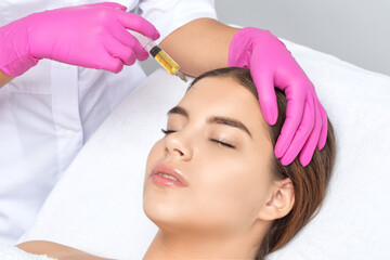 Cosmetologist does prp therapy on the face of a beautiful woman in a beauty salon. Female aesthetic cosmetology in a beauty salon.