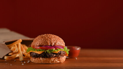 Delicious grilled beef burger and french fries on the table with copy space in fast food shop
