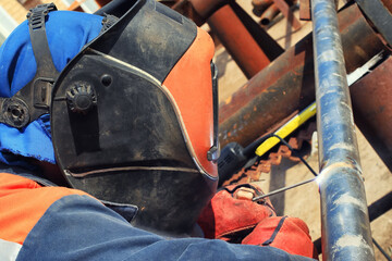 Welder in the mask and protective clothing is gaining increased cladding weld
