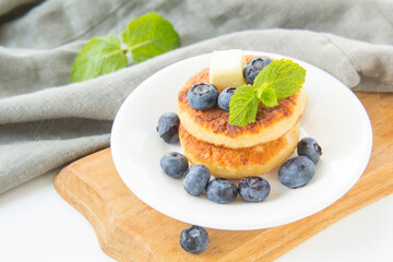 A healthy breakfast of pancakes, berries, butter, and honey