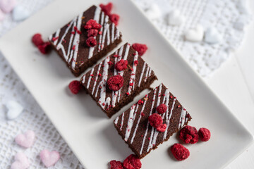 Obraz na płótnie Canvas rich dark cocolate brownie cake desert with freeze dried raspsberries 