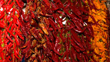 Fototapeta premium Multicolored chili peppers hanging on threads in a Funchal market in Madeira