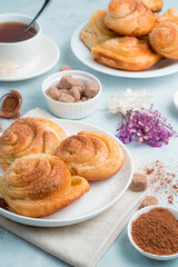 Homemade cakes, snail buns with sugar on a soft blue background.
