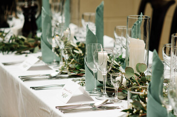 Elegant table setting at the restaurant. Wedding banquet with floral decoration on table, cards,...