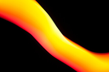 Abstract yellow and orange light painting curving on a black background.